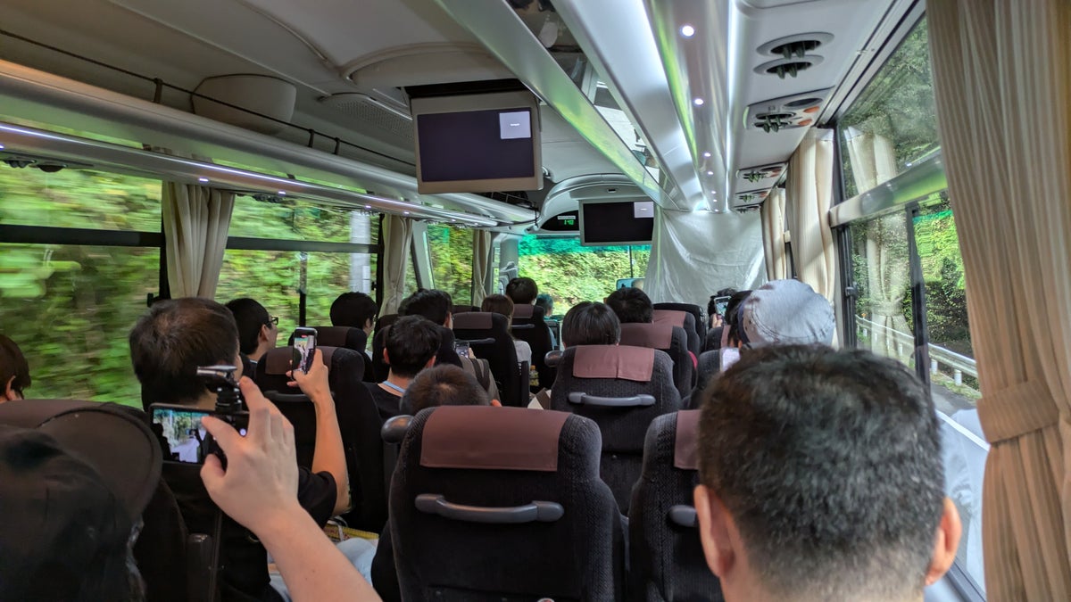 Participants photographing the monitor inside a sightseeing bus touring Niimi City
